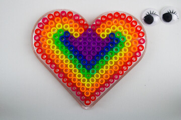 heart with eyes looking at it geometric gay pride symbol made with toys
