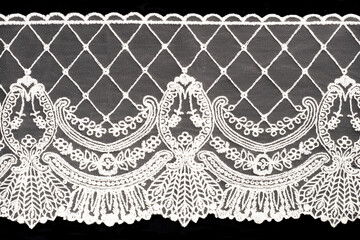 White lace on black background isolated horizontally. Macro - obrazy, fototapety, plakaty