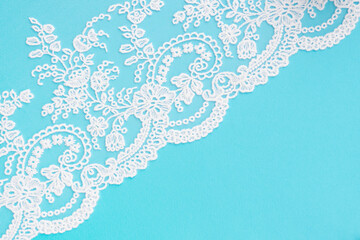 White lace with flowers and leaves with pattern on blue diagonally