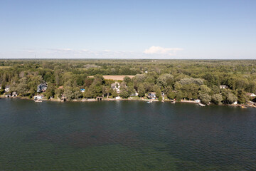 Orillia lake front green trees and lake blue skies drone shot 