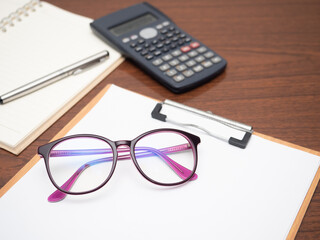 Closeup workspace on table, Document board calculator glasses on table