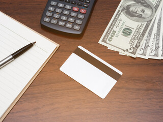 Credit card with calculator workspace and money on table top view
