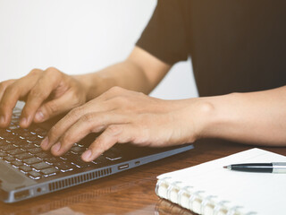 Closeup hand using laptop for working on the desk