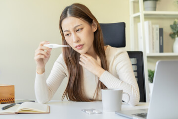 Sick, influenza asian young woman, girl headache have a fever, flu and check thermometer measure body temperature, feel illness while sitting work at home, office. Health care, infection of covid-19