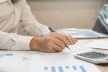 Close up hand of stress asian young employee business man, male calculate tax income and expenses, bills, credit card for payment or payday on table at home office. Financial, finance people concept.