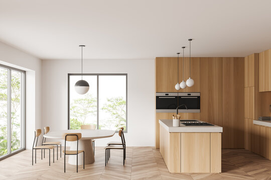 Light kitchen interior with chairs and table, cooking area and panoramic window