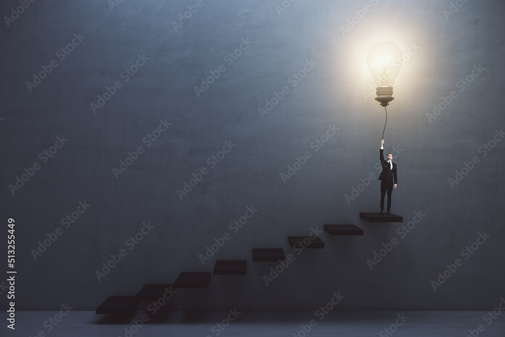 Aufkleber Creative and idea concept with front view on man in suit on the top of stairway turning on big light bulb on dark concrete background in empty hall