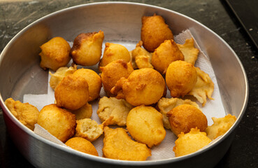 putting sugar and cinnamon in a fried dough known as a 'bolinho de chuva'. a typical and traditional Brazilian recipe