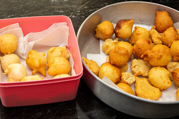 putting sugar and cinnamon in a fried dough known as a 'bolinho de chuva'. a typical and traditional Brazilian recipe