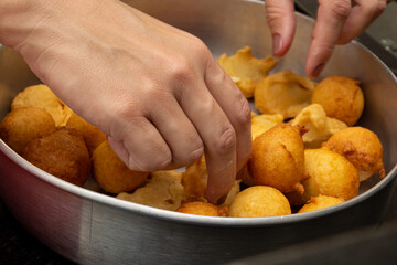 putting sugar and cinnamon in a fried dough known as a 'bolinho de chuva'. a typical and traditional Brazilian recipe