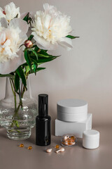 Skin care, beauty concept. Cosmetics for facial skin care and a bouquet of white peonies on a light...