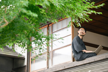 Fototapeta premium 田舎でリモートなどをする人 窓際