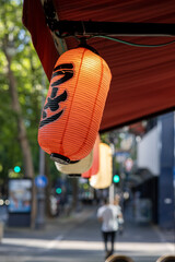 A paper lantern with Japanese writing on a street in Cologne