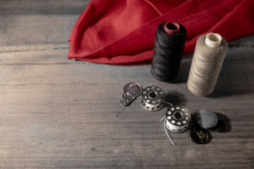 Fototapeta na wymiar red cloth and thread. stitching tools image 