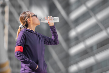Young sports healthy woman drinking water.