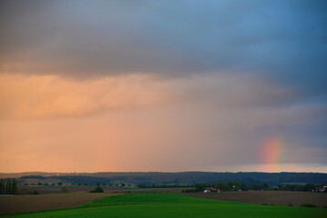 Fototapeta na wymiar Wolkenhimmel mit Regenbogen, abends