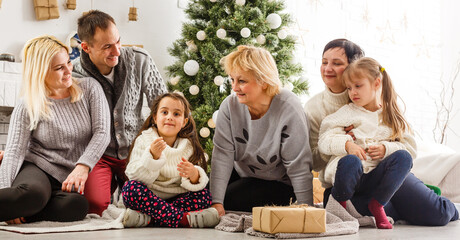 happy young family holding christmas gift and smiling