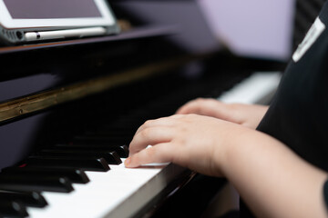 kid hands press piano key for music online learning