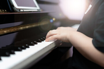 kid hands press piano key for music online learning