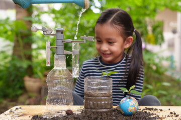 Blurred of little girl is learning science experiment at home and planting with recycle plastic bottle, concept of STEM, education, montessori, nature, environment, weather, climate change for kid. - obrazy, fototapety, plakaty