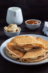 Pancakes with chocolate banana filling. Wooden rustic table, sweet delicious dessert.