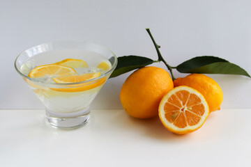 water with lemon. ripe lemons and a glass glass with homemade lemonade.