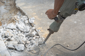 Workers are digging cement floors to repair car roads.