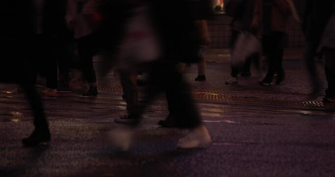 A high speed shooting of walking people body parts at Shibuya crossing rainy day