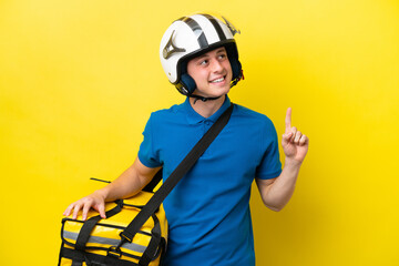 Young Brazilian man with thermal backpack isolated on yellow background pointing up a great idea