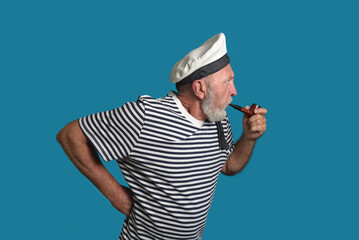 Attentive sailor. Old sailor with a smoking pipe on a blue background isolated