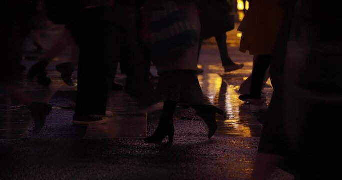 A high speed shooting of walking people body parts at Shibuya crossing rainy day