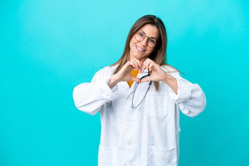 Middle age woman isolated on blue background wearing a doctor gown making a heart with hands