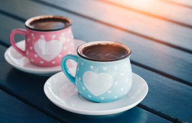 Closeup image of two blue cups of hot coffee on vintage wooden table in cafe