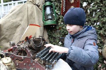 Boy typing on vintage typewriter