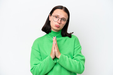 Young caucasian woman isolated on white background keeps palm together. Person asks for something