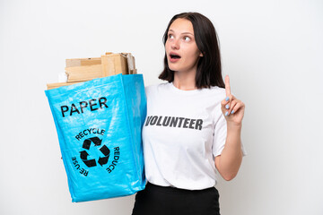 Young caucasian woman holding a recycling bag full of paper to recycle isolated on white background thinking an idea pointing the finger up