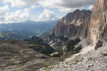 Mountain landscape with lake, valley and clouds on background, Dolomites, Italian Alps.