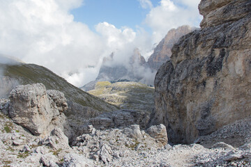 Mountain peaks seeing through clouds in a sunny day, Dolomites, Italian Alps.
