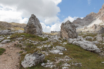 Fototapeta na wymiar Mountain landscape in a sunny day. Two rock outcrop in a valley surrounded by mountain massif, Dolomites, Italian Alps.