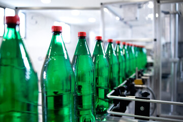 Industrial production of drinking water and bottles being moved on conveyor belt.