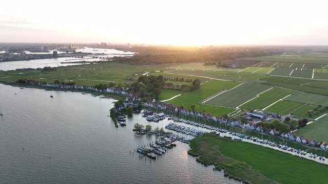 Durgerdam local dyke village with old traditional wooden houses in the north of Amsterdam. Harbour maritime countryside aerial landscape at sunset. Dutch Holland landscape.