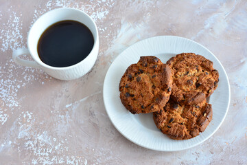 american cookies with chocolate on white plate and cup of coffee