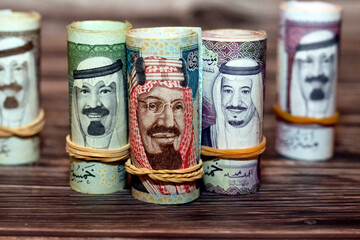 Saudi Arabia money roll riyals banknotes isolated on wooden background, Saudi riyals cash money...