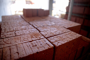 pallets and packages of freshly produced red bricks in a construction warehouse on the street....