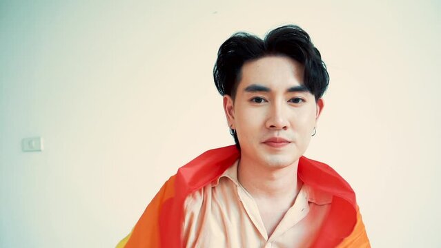 Smiling transgender man with pride flag isolated on white background with copy space. People lifestyle fashion lgbtq concept.