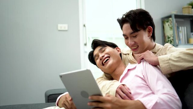 Homosexual couple enjoying using digital tablet at home