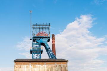 Old rusty coal mine shaft. In the background the chimney of the heating plant. Siemianowice, Poland