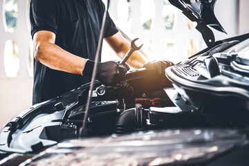Close-up hand auto mechanic holding the wrench to repairing car engine problem. Concepts of check...