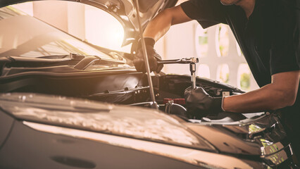 Close-up hand auto mechanic using the wrench to repairing car engine problem. Concepts of check and fix car and maintenance servicing.