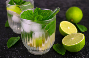 Non-alcoholic mojito with lime on a black background. Refreshing summer drink. Close-up background.